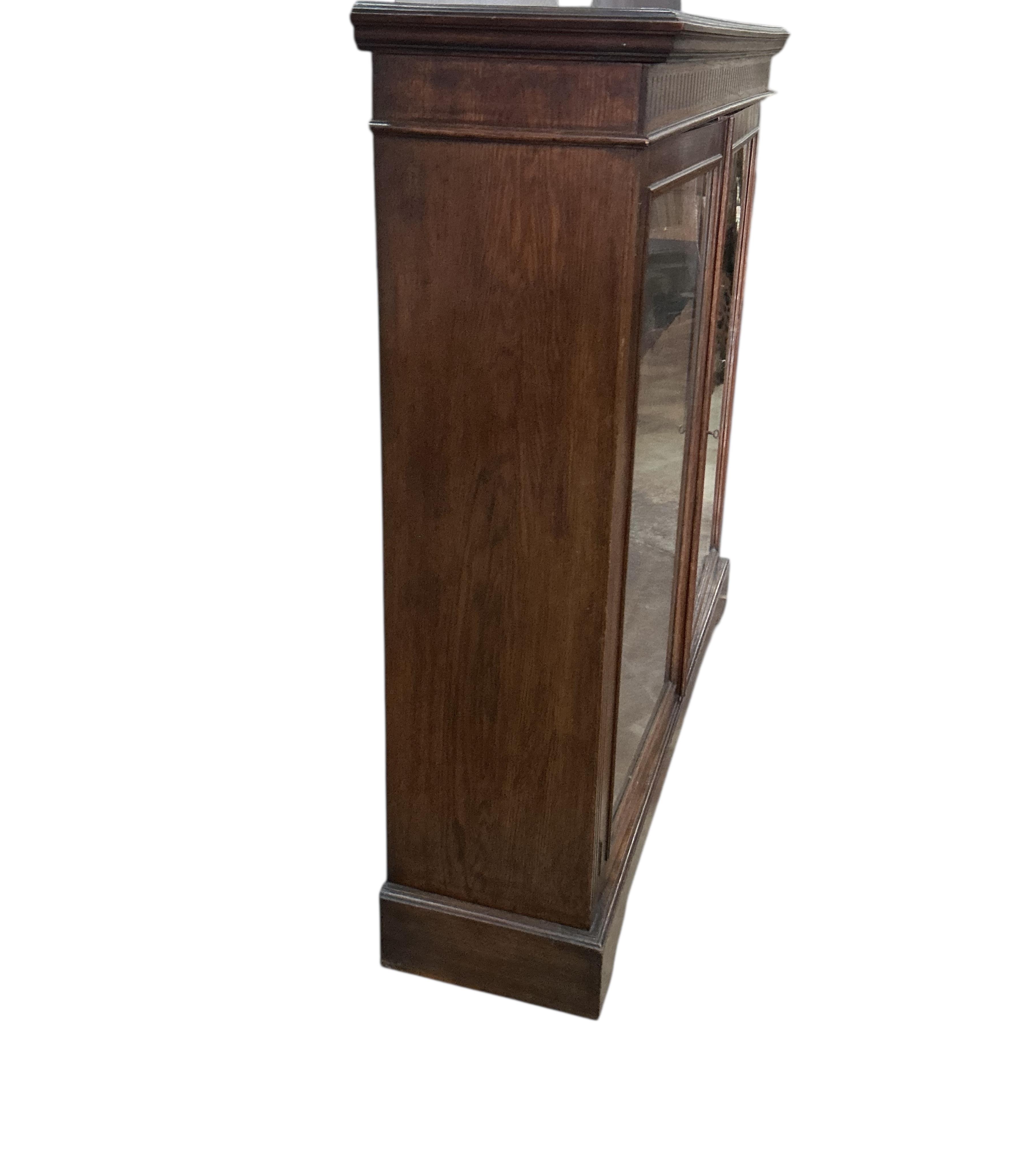 A late Victorian glazed oak bookcase, width 122cm, depth 33cm, height 118cm